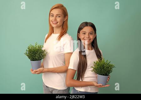 Adoptivfamilie von adoptierten Tochter Kind und Frau Mutter lächeln mit Topfpflanzen, Pflege Stockfoto