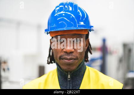 Afrikanischer Ingenieur, der in der Roboterfabrik arbeitet - Industrie- und Technologiekonzept - Schwerpunkt Mund Stockfoto