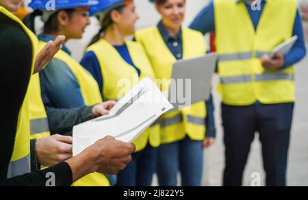 Ingenieure, die in der Roboterfabrik arbeiten - Industrie- und Technologiekonzept - Fokus auf afrikanische Menschenhand Stockfoto