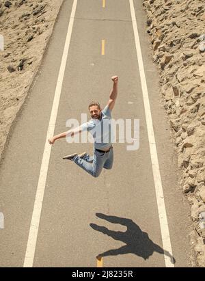 Glücklich reifen athletischen Mann springen auf Straße im Freien, Motivation Stockfoto