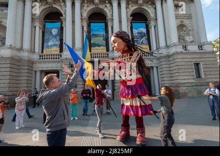 Amal, eine riesige Marionette, die ein neun Jahre altes syrisches Flüchtlingsmädchen darstellt, das beim Besuch im Zentrum von Lemberg die ukrainische Flagge hält. Die 3,5 Meter lange Riesenpuppe feiert die menschliche Migration und ist mehr als 8000 Kilometer von der syrischen türkischen Grenze durch Europa bis nach Großbritannien gereist. Als Teil der Bewegung wurde Amal zu jungen Flüchtlingen in der Ukraine gebracht und ist jetzt im Zentrum von Lemberg zu sehen. Russland marschierte am 24. Februar 2022 in die Ukraine ein und löste damit den größten militärischen Angriff in Europa seit dem Zweiten Weltkrieg aus (Foto von Mykola Tys/SOPA Images/Sipa USA) Stockfoto