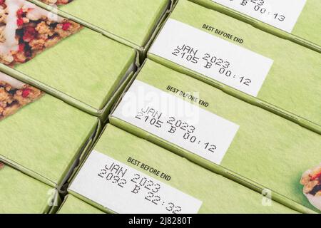 Close Shot of Food Best Before Date / BBD auf Karton mit Tesco 'Summer Fruits' Müsliriegel. Für Lebensmittelverschwendung und Wegwerfen von Lebensmitteln. Stockfoto