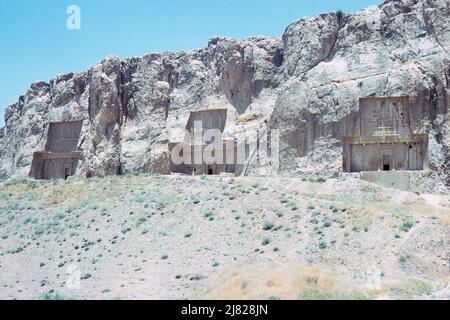 Nekropole von Naqsh-e Rustam, die letzte Ruhestätte von vier achämeniden Königen (von links nach rechts) Gräber von Darius II, Artaxerxes I und Darius I. das vierte Grab von Xerxes I wurde nicht gezeigt. Standort befindet sich etwa 12 km nordwestlich von Persepolis, in der Provinz Fars, Iran. Archivbild aus dem Jahr 1976 Stockfoto