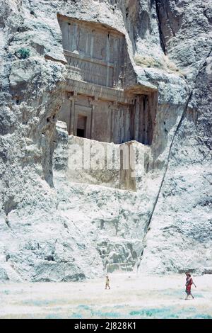 Nekropole von Naqsh-e Rustam, die letzte Ruhestätte der vier achämeniden Könige Darius II, Artaxerxes I, Darius I und Xerxes I. Dieses Bild zeigt Touristen vor dem Grab von Artaxerxes I. Standort befindet sich etwa 12 km nordwestlich von Persepolis, in der Provinz Fars, Iran. Archivbild aus dem Jahr 1976 Stockfoto