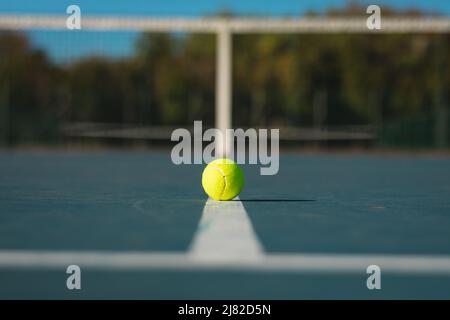 Grüner Ball auf weißer Linie auf leerem Platz an sonnigen Tagen Stockfoto