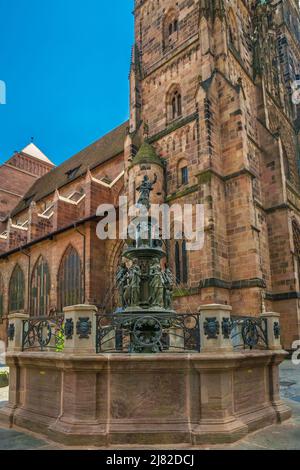 Schöner Blick auf den Tugendbrunnen vor der Kirche St. Lorenz in Nürnberg. Der Brunnen der Spätrenaissance aus Bronze... Stockfoto