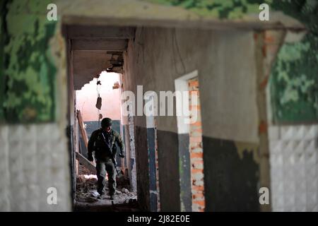 Biskvitne, Ukraine. 08.. Mai 2022. Ein ukrainischer Soldat, der in einem Haus nach Spuren der Russen im Dorf Biskvitne sucht. Ukrainische Soldaten befreiten das kleine Dorf Biskvitne außerhalb von Charkiw, wo russische Truppen sich kürzlich nach intensiven Kämpfen mit ukrainischen Truppen zurückzogen. Russland marschierte am 24. Februar 2022 in die Ukraine ein und löste damit den größten militärischen Angriff in Europa seit dem Zweiten Weltkrieg aus Kredit: SOPA Images Limited/Alamy Live Nachrichten Stockfoto