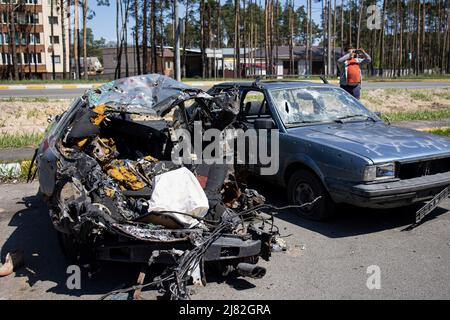Irpin, Ukraine. 10.. Mai 2022. Ein Zivilist fotografiert auf dem Autofriedhof mit seinem Handy. Ein Parkplatz in Irpin wurde im März zu Beginn des russisch-ukrainischen Krieges zu einem Autofriedhof für alle beschädigten Fahrzeuge durch die russische Armee umgeschlagen, um die Stadt zu belagern und Kiew zu erobern. Russland marschierte am 24. Februar 2022 in die Ukraine ein und löste damit den größten militärischen Angriff in Europa seit dem Zweiten Weltkrieg aus (Foto von Hesther Ng/SOPA Images/Sipa USA) Quelle: SIPA USA/Alamy Live News Stockfoto