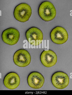 Draufsicht auf Kiwi-Scheiben auf grauem Hintergrund Stockfoto