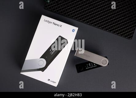 Russland, Krasnodar - 15. April 2022: Hardware Kryptowährung Wallet mit Box auf dunklem Hintergrund. Stockfoto