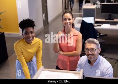 Porträt von glücklichen, multirassischen Geschäftskollegen bei Treffen am modernen Arbeitsplatz Stockfoto