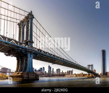 New York, USA - 28. April 2022: Seitenansicht der Manhattan Bridge-Struktur und der New Yorker Gebäude Stockfoto