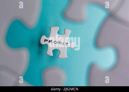 Profit Wort auf Puzzle-Stücke isoliert auf blauem Hintergrund. Geschäftskonzept. Stockfoto