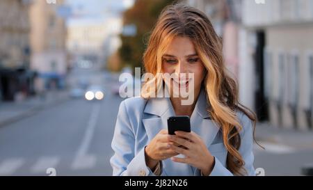 Porträt kaukasischen Mädchen Geschäftsfrau Blick in Handy freut Sieg gute Nachrichten chatten im Netz erhält Nachricht von Freund erfolgreich Stockfoto