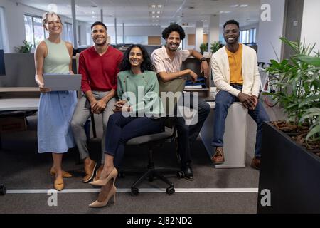 In voller Länge Porträt von lächelnden, multirassischen Beratern an modernen Arbeitsplätzen Stockfoto