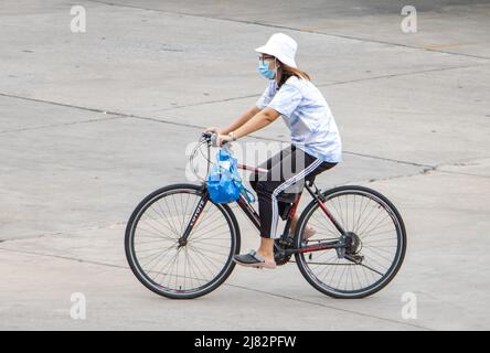 SAMUT PRAKAN, THAILAND, APR 02 2022, Eine Frau fährt auf der Straße mit dem Fahrrad Stockfoto