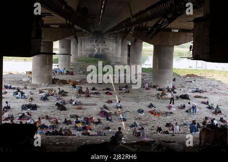 Neu-Delhi, Indien. 12.. Mai 2022. Menschen ruhen sich unter einer Brücke aus, um sich vom heißen Sommertag in Neu-Delhi, Indien, zu erholen, 12. Mai 2022. Quelle: Javed Dar/Xinhua/Alamy Live News Stockfoto
