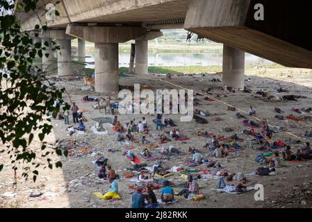 Neu-Delhi, Indien. 12.. Mai 2022. Menschen ruhen sich unter einer Brücke aus, um sich vom heißen Sommertag in Neu-Delhi, Indien, zu erholen, 12. Mai 2022. Quelle: Javed Dar/Xinhua/Alamy Live News Stockfoto