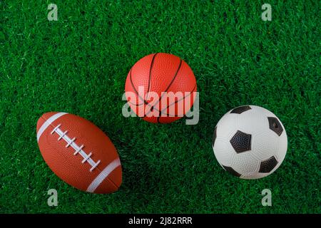 Fußball, Basketball und Fußballbälle auf grünem Gras. Stockfoto
