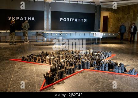 Kiew, Ukraine. 10.. Mai 2022. Eine Sammlung gefallener russischer Militärstiefel befindet sich am Eingang des Nationalmuseums für die Geschichte der Ukraine. Die Ausstellung „Ukraine: Kreuzigung“ wird im Nationalmuseum für Geschichte der Ukraine eröffnet, das der russischen Invasion in die Ukraine, insbesondere in Kiew, gewidmet ist. Die Ausstellung zeigte eine Sammlung von Zeugnissen des Krieges aus den besetzten Dörfern rund um Kiew. Russland marschierte am 24. Februar 2022 in die Ukraine ein und löste damit den größten militärischen Angriff in Europa seit dem Zweiten Weltkrieg aus (Bild: © Hesther Ng/SOPA Images via ZUMA Press Wire) Stockfoto