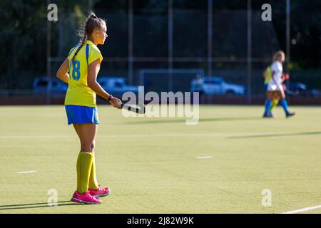 Junge Feldhockey-Spielerin mit Stock während des Spiels Stockfoto