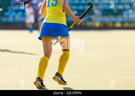 Junge Feldhockey-Spielerin mit Stock während des Spiels Stockfoto