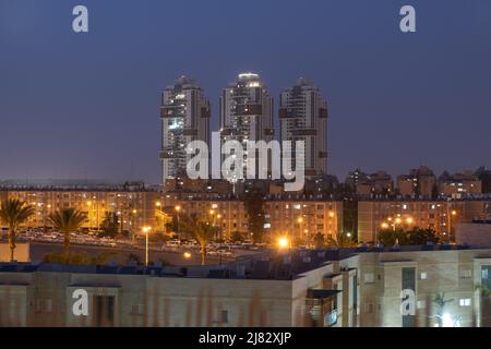 Nachtstadt im Süden Israels. Moderne Architektur in der Stadt, Hochhäuser und alte Gebäude in Beer Sheba Nachbarschaft. Immobilien-Apartment Stockfoto
