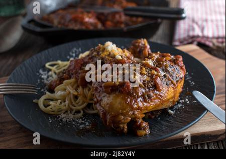 Hähnchenschenkel mit Pasta, Tomatensauce und Parmesankäse Stockfoto