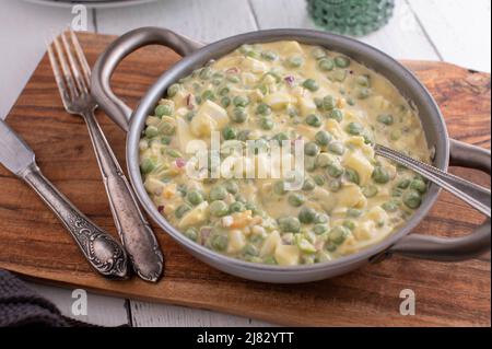Traditioneller Erbsensalat aus grünen Erbsen, gekochten Eiern, roten Zwiebeln und Mayonnaise Stockfoto