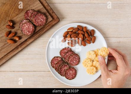 Vorspeise Snack mit Salami, Mandeln und Parmesan-Chips Stockfoto