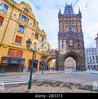 PRAG, TSCHECHISCHE REPUBLIK - 5. MÄRZ 2022: Blick auf den historischen Pulverturm und die Seitenwand des Gemeindehauses mit einer alten Straßenlaterne im Vordergrund, Stockfoto