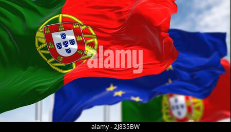 Detail der im Wind winkenden Nationalflagge Portugals mit verschwommener flagge der europäischen Union im Hintergrund an einem klaren Tag. Demokratie und Politik. Stockfoto