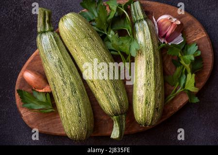 Frische Zucchini auf Holzschneidebrett, gesundes Gemüsegericht Stockfoto