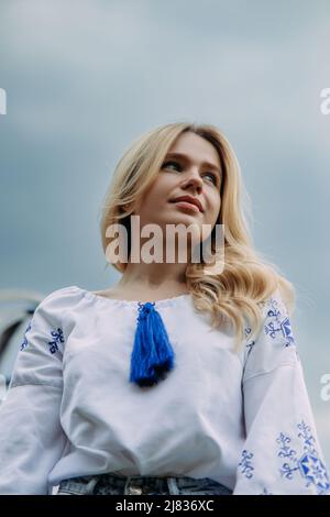 Porträt einer jungen ukrainischen Frau in nationalen traditionellen bestickten Hemd vor Himmel Hintergrund gekleidet. Stockfoto