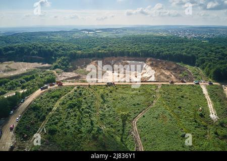 Luftaufnahme des Tagebaus von Kalksteinmaterialien für die Bauindustrie mit Baggern und Muldenkipper Stockfoto