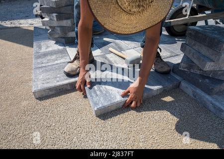 Gehweg Fliesen, Ziegel oder Pflaster werden auf einem Grundstück in installiert. Naples, Florida zwischen einigen Gebäuden und einigen Sportanlagen. Stockfoto