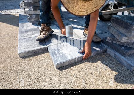 Gehweg Fliesen, Ziegel oder Pflaster werden auf einem Grundstück in installiert. Naples, Florida zwischen einigen Gebäuden und einigen Sportanlagen. Stockfoto