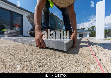 Gehweg Fliesen, Ziegel oder Pflaster werden auf einem Grundstück in installiert. Naples, Florida zwischen einigen Gebäuden und einigen Sportanlagen. Stockfoto