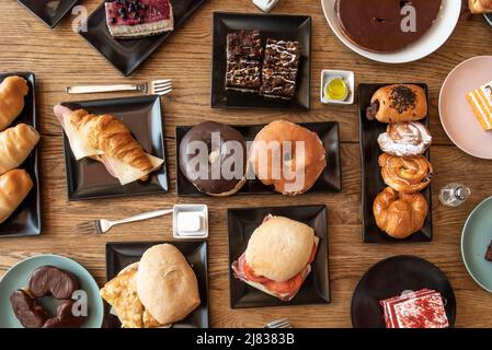 Bild von oben mit Sandwiches, Donuts, Gebäck, Kuchen und Süßigkeiten zum Frühstück und Snacks Stockfoto