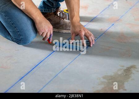 Bauarbeiter misst und umreißt den Boden eines erschwinglichen Wohnkomplex Stockfoto