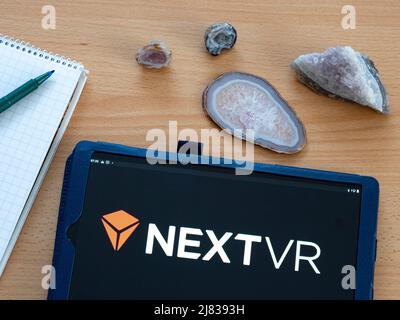 In this photo illustration NextVR, Inc. owned by Apple Inc. logo seen displayed on a tablet. Stock Photo