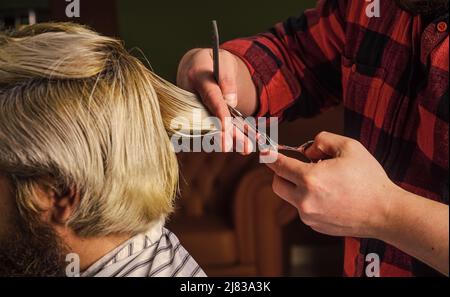 Retro und Vintage. Design Haarschnitt. Friseur-Werkzeuge in Friseursalon. Friseur Schneiden Haare von männlichen Kunden. Friseur, der Kunden im Friseurladen bedient Stockfoto