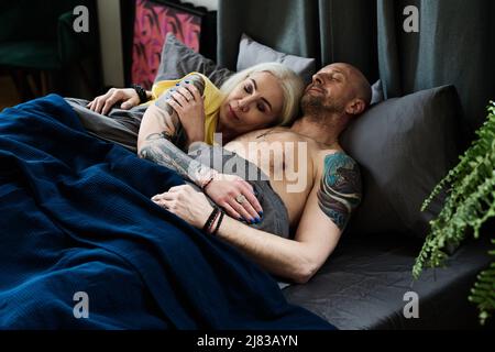 Tätowierte reife kaukasische Mann und Frau verliebt schlafen zusammen im Bett zu Hause am Morgen Stockfoto