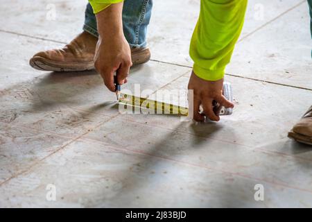 Bauarbeiter skizziert vom Bauplan bis zum Beton für die Einrahmung der Installation. Stockfoto