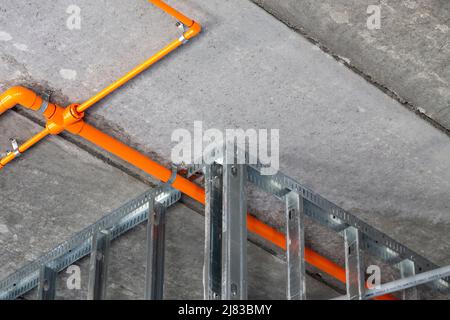 Sprinklerrohre zwischen verzinktem Stahlrahmen an der Decke eines im Bau befindlichen mehrstöckigen Hotelzimmers. Stockfoto