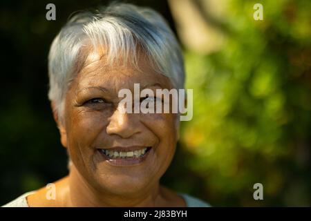 Nahaufnahme eines lächelnden Senioren aus der Birazialzeit mit kurzen grauen Haaren im Park Stockfoto