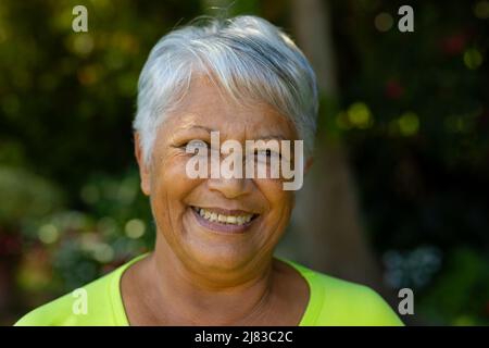 Nahaufnahme eines lächelnden Senioren aus der Birazialzeit mit kurzen grauen Haaren im Hof Stockfoto