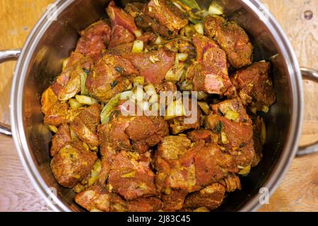 Vorbereitung jamaikanischer Ziegenpuder - mariniert in Puder, Zwiebeln, Thymian, allen Gewürzen und Knoblauch. Von oben. Stockfoto