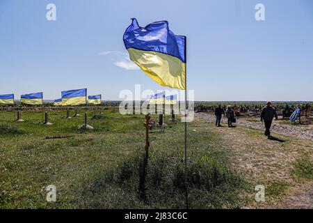 Dnipro, Dnipro, Ukraine. 12th May, 2022. People walk past at a mass grave for Ukrainian soldiers who have died since since both the 2014 Donbas War and 2022 Russian War started, amid the Russian invasion. (Credit Image: © Daniel Ceng Shou-Yi/ZUMA Press Wire) Stock Photo