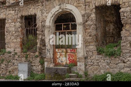 Verkommen bombardierte über das gewachsene Gebäude in Bosnien-Herzegowina mit Graffiti und zerbrochenen Fenstern als Relikt des Konflikts Stockfoto